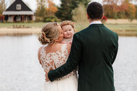 bride and groom kissing baby