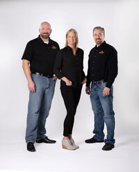A real estate team of three professionals in a full length pose on a white backdrop at Studio 64 Photography.
