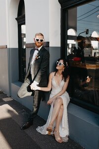 bride and groom stand outside of cool shop in fitzroy