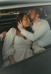 Engaged couple taking engagement photos in their vintage car in Minnesota