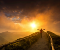 Woman hiking up a mountain at sunrise