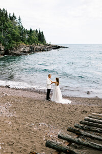 Bride and groom saying marriage vows in private of lake Superior on the North Shore in Minnesota. 