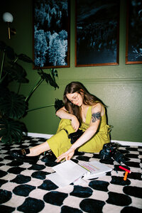 woman sits on floor with camera equipment 