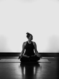 Alex Paige in black and white photo throwing powder in king pigeon pose