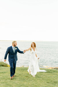 cliff house coastal wedding in Maine couple holding hands