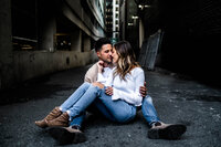 Luxury Portraits by Moving Mountains Photography in NC - Photo of a couple sitting on the ground while leaning towards each other.