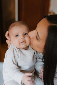 Indian mother kissing her infant son during newborn photos