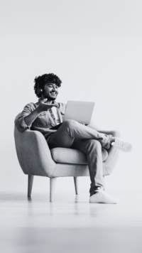 man in chair on computer smiling