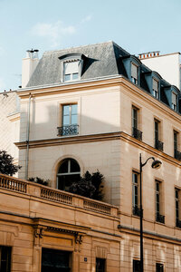 Classic Parisian apartment building with mansard roof representing European city destinations and radiating quiet opulence and classic charm. Tailored Oasis Travel Co.