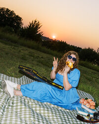 Flash photo of Allison Bolin Texas wedding photographer eating pizza on a picnic blanket