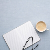 Notebook, coffee and glasses on a blue background
