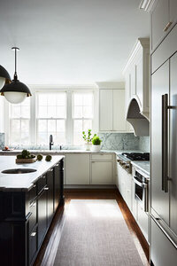 Top interior designers in Boston featured in Boston Globe Magazine. See our modern white kitchen with black island and Allied Maker pendants.