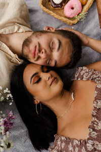 man and woman laying next to each other with their eyes closed