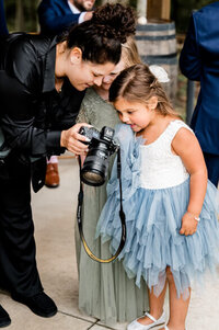bts photo of photographer showing flower girl picture