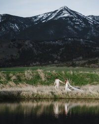 Bride and groom posing in front of a scenic mountain backdrop in Montana