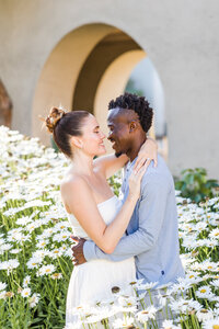 engaged couple standing in white daisies