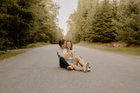 man and woman sitting on road