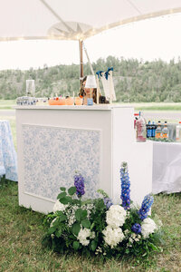 Blue and white garden party wedding with custom floral bar front.
