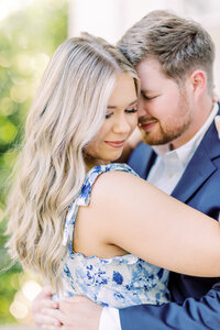 Engaged couple embracing and touching foreheads