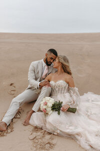 Bride and groom sharing a romantic moment in the Michigan sand dunes during their wedding