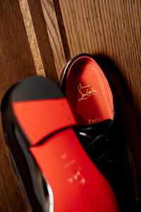 A close up of an engaged couple holding hands with a focus on her engagement ring.