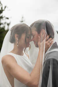 Bride and groom sharing a tender, quiet moment alone amidst the beauty of their wedding day.