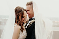 Bride and groom share a kiss under veil organized by seattle wedding planners
