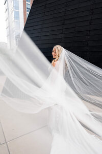 bride posing with large veil on wedding day in downtown cleveland