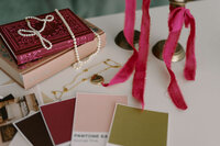 books, colored papers, and ribbons strewn across a table