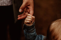 child holds parents finger