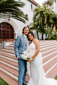 newlyweds pose on city hall staircase