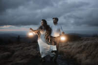 bride and groom hike on mountain top during golden hour on roan mountain