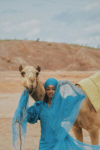 Woman walking with a camel in the Sahara desert in Morocco