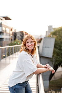 woman standing on a bridge smiling