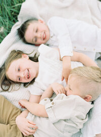 children laying on blanket laughing