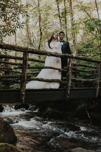 newlyweds on bride over creek