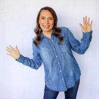 Stacey from Xanthe Bookkeeping smiling in a jean shirt with hands raised in excitement, shown in the website footer.