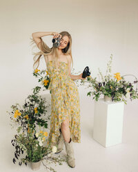 sunnie heers, photographer, posing with her camera and wildflowers