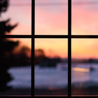 A blurred image of a sunset in Kingston though the panes of a window.
