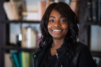 Image of woman, smiling, standing in a library