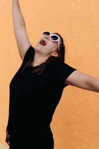 A woman member of the LIVE BIG Collective posing confidently with sunglasses on 