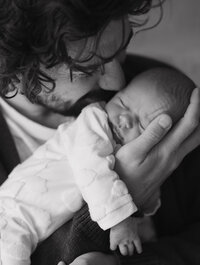 Brother and sister hugging and laughing in black and white image