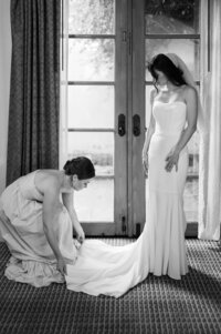 Brideasmaid adjusting brides train on dress at The Royal Palms