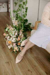 Floral arrangements on the floor next to where wedding planner, Zelie & Co., is sitting