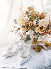 Neutral wedding bouquet with wedding shoes