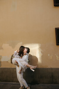 bride carrying groom in the streets of Florence, Italy