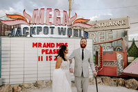 A couple smiles at The Neon Museum during their wedding.