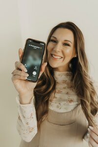 woman smiling holding phone