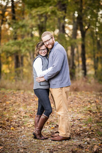 couple posing in fall leaves