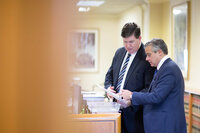 Attorneys standing sharing a document in a hallway